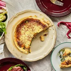 En saftig quiche lorraine med en gyllene skorpa, serverad med en fräsch sallad.