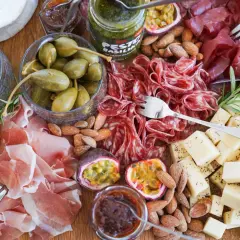 En härlig charkbricka med salami, prosciutto, ost, oliver, cornichoner, nötter och passionsfrukt. Perfekt för mingel! Här är några charkbricka tips.