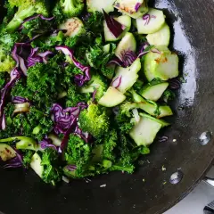 En matig sallad med grönkål, rödkål och broccoli i en wokpanna.
