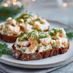Två toast Skagen på mörkt bröd, toppade med räkor, majonnäs och dill. En klassisk svensk delikatess.