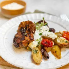 Krispiga kycklingbitar med rostade potatisar, tomater, oliver och en krämig sås till kyckling.