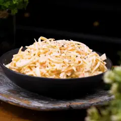 En skål med krämig, godaste coleslaw, toppad med nymalen svartpeppar. Perfekt tillbehör!