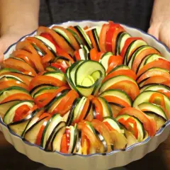 Vacker ratatouille i ugnsform, redo för ugnen. Ett perfekt ratatouille recept med skivade grönsaker som tomat, zucchini och aubergine.