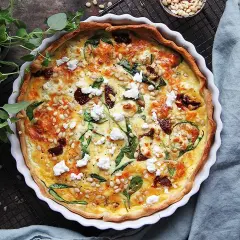 En gyllene matpaj med spenat, soltorkade tomater och pinjenötter. Ett perfekt matpaj recept för en härlig måltid.