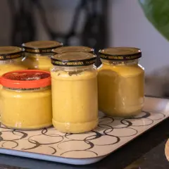 Burkar med hemlagad sambal oelek recept på en bricka. En skål med citroner syns i bakgrunden.
