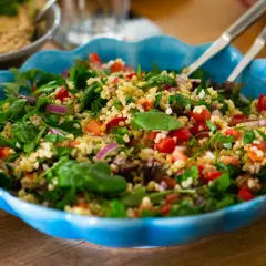 En fräsch tabbouleh med bulgur, tomater, lök och örter i en blå skål. Perfekt för ett lätt lunchrecept.