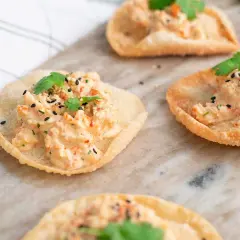 Små, krispiga tortillachips med en krämig topping av räkor och örter, toppade med svarta sesamfrön. Perfekta som enkla tilltugg.