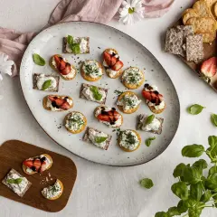 En härlig midsommar buffe med snittar på kex och ost, toppade med jordgubbar och örter.