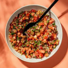 En skål med färsk pico de gallo, en härlig blandning av hackade tomater, lök och koriander, redo att serveras.