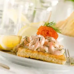 En perfekt toast skagen med krämiga räkor, rom och dill, serverad med citronklyfta. En riktig delikatess!