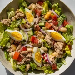 En fräsch tonfisksallad med ägg, bönor, tomat och lök. Perfekt som en lätt lunch eller middag med god dressing till tonfisksallad.