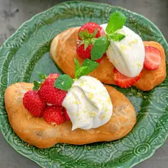 Två friterade langos med grädde, färska jordgubbar och mynta. Ett enkelt langos recept för en härlig fika.