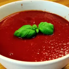En skål med tomatsoppa, så röd att den nästan ser ut som el diablo. Garnerad med färsk basilika.