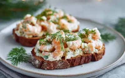 Två toast Skagen på mörkt bröd, toppade med räkor, majonnäs och dill. En klassisk svensk delikatess.
