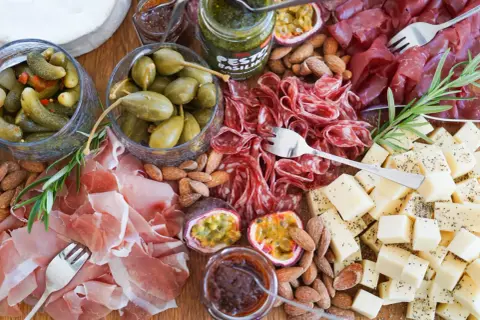 En härlig charkbricka med salami, prosciutto, ost, oliver, cornichoner, nötter och passionsfrukt. Perfekt för mingel! Här är några charkbricka tips.