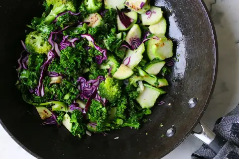 En matig sallad med grönkål, rödkål och broccoli i en wokpanna.