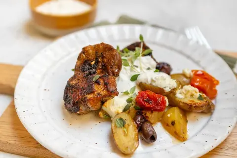 Krispiga kycklingbitar med rostade potatisar, tomater, oliver och en krämig sås till kyckling.