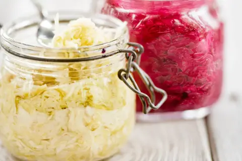Två glasburkar med surkål, en ljus och en röd. Perfekt för ditt surkål recept!