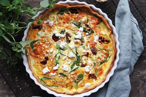En gyllene matpaj med spenat, soltorkade tomater och pinjenötter. Ett perfekt matpaj recept för en härlig måltid.