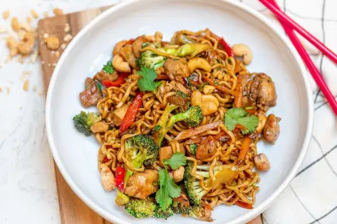 En skål med nudlar, kyckling, broccoli, paprika och cashewnötter. Perfekt för enkla middagar.