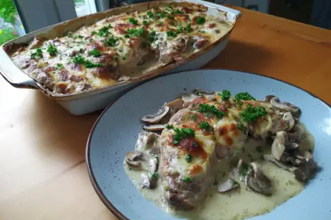 En krämig grekisk pyttipanna med svamp och gratinerad ost, toppad med persilja. Serveras i en ugnsform och på en tallrik.