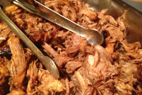 Saftigt pulled pork i ugn, redo att serveras med tång.