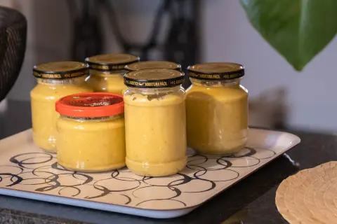 Burkar med hemlagad sambal oelek recept på en bricka. En skål med citroner syns i bakgrunden.