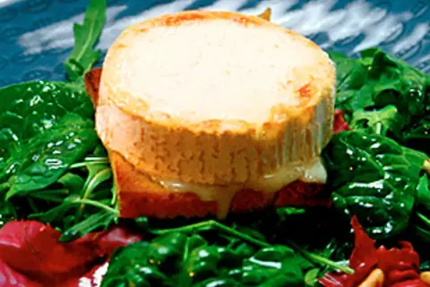 Varm chevre chaud på rostat bröd, serverad med en fräsch sallad av spenat och ruccola.