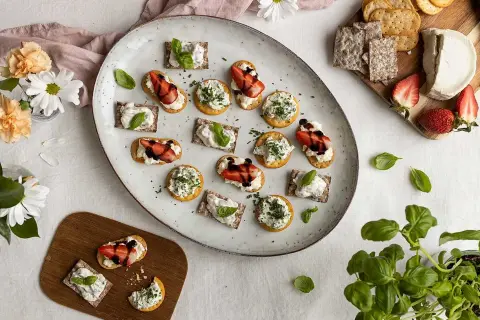 En härlig midsommar buffe med snittar på kex och ost, toppade med jordgubbar och örter.