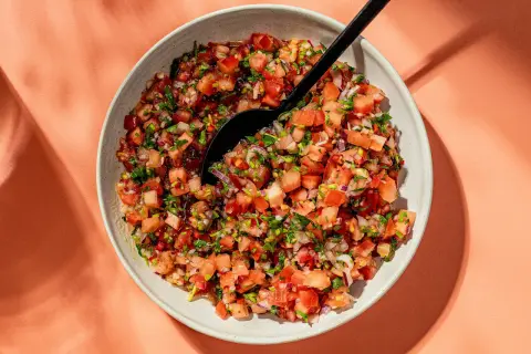 En skål med färsk pico de gallo, en härlig blandning av hackade tomater, lök och koriander, redo att serveras.