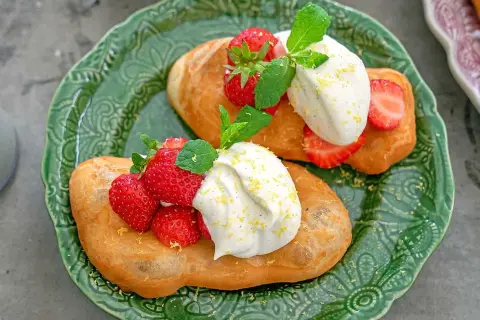 Två friterade langos med grädde, färska jordgubbar och mynta. Ett enkelt langos recept för en härlig fika.