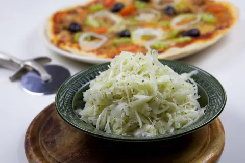 En skål med krispig pizzasallad, perfekt till din hemgjorda pizza. Här är ett enkelt pizzasallad recept!