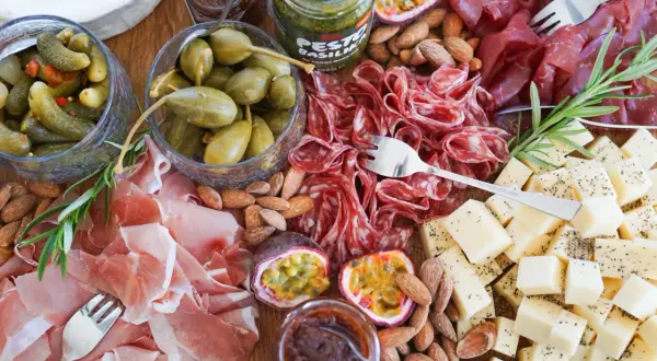 En härlig charkbricka med salami, prosciutto, ost, oliver, cornichoner, nötter och passionsfrukt. Perfekt för mingel! Här är några charkbricka tips.