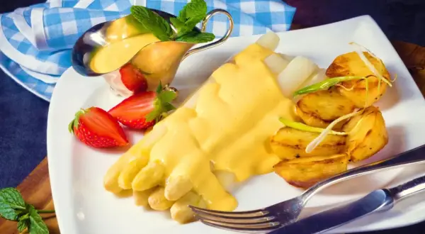 Vit sparris med krämig hollandaisesås, rostade potatisar och jordgubbar. Ett perfekt hollandaisesås recept för en lyxig måltid.