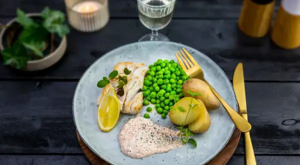 En tallrik med fisk, potatis, ärtor och en krämig romsås. Ett perfekt romsås recept för en härlig middag.