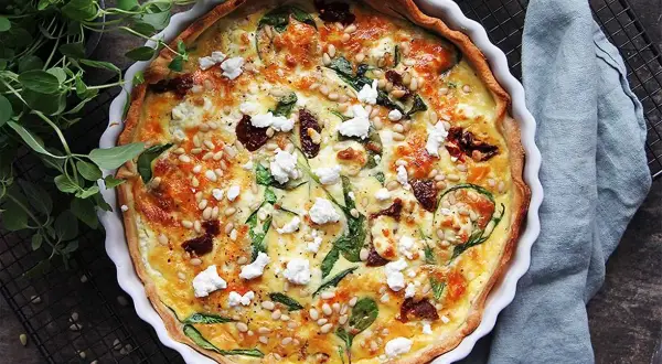 En gyllene matpaj med spenat, soltorkade tomater och pinjenötter. Ett perfekt matpaj recept för en härlig måltid.