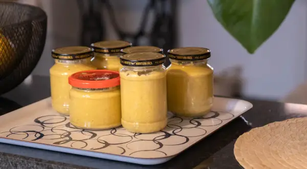 Burkar med hemlagad sambal oelek recept på en bricka. En skål med citroner syns i bakgrunden.