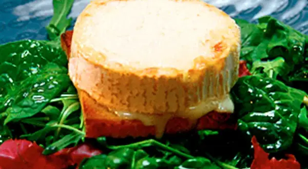 Varm chevre chaud på rostat bröd, serverad med en fräsch sallad av spenat och ruccola.