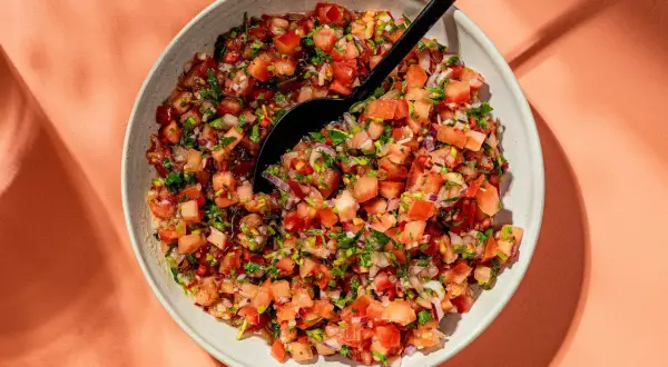 En skål med färsk pico de gallo, en härlig blandning av hackade tomater, lök och koriander, redo att serveras.