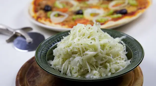 En skål med krispig pizzasallad, perfekt till din hemgjorda pizza. Här är ett enkelt pizzasallad recept!