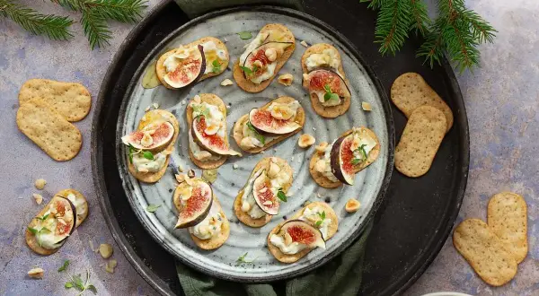 Smakliga snittar med fikon, ost och nötter på kex. Ett enkelt och elegant snittar recept för festen.