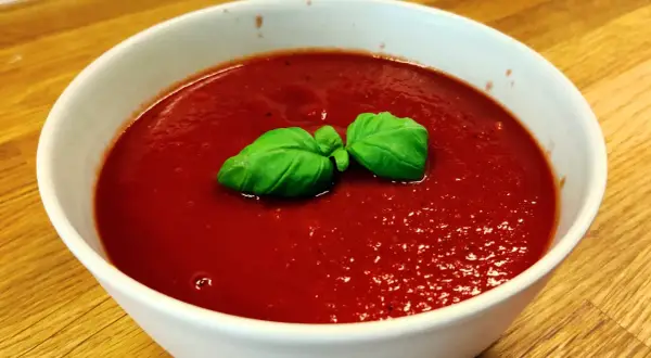 En skål med tomatsoppa, så röd att den nästan ser ut som el diablo. Garnerad med färsk basilika.