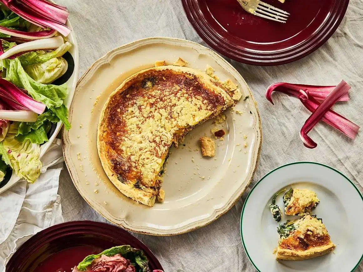 En saftig quiche lorraine med en gyllene skorpa, serverad med en fräsch sallad.