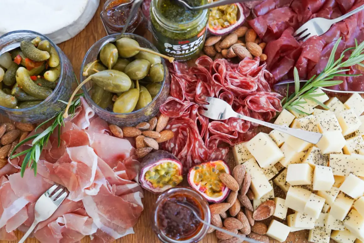 En härlig charkbricka med salami, prosciutto, ost, oliver, cornichoner, nötter och passionsfrukt. Perfekt för mingel! Här är några charkbricka tips.