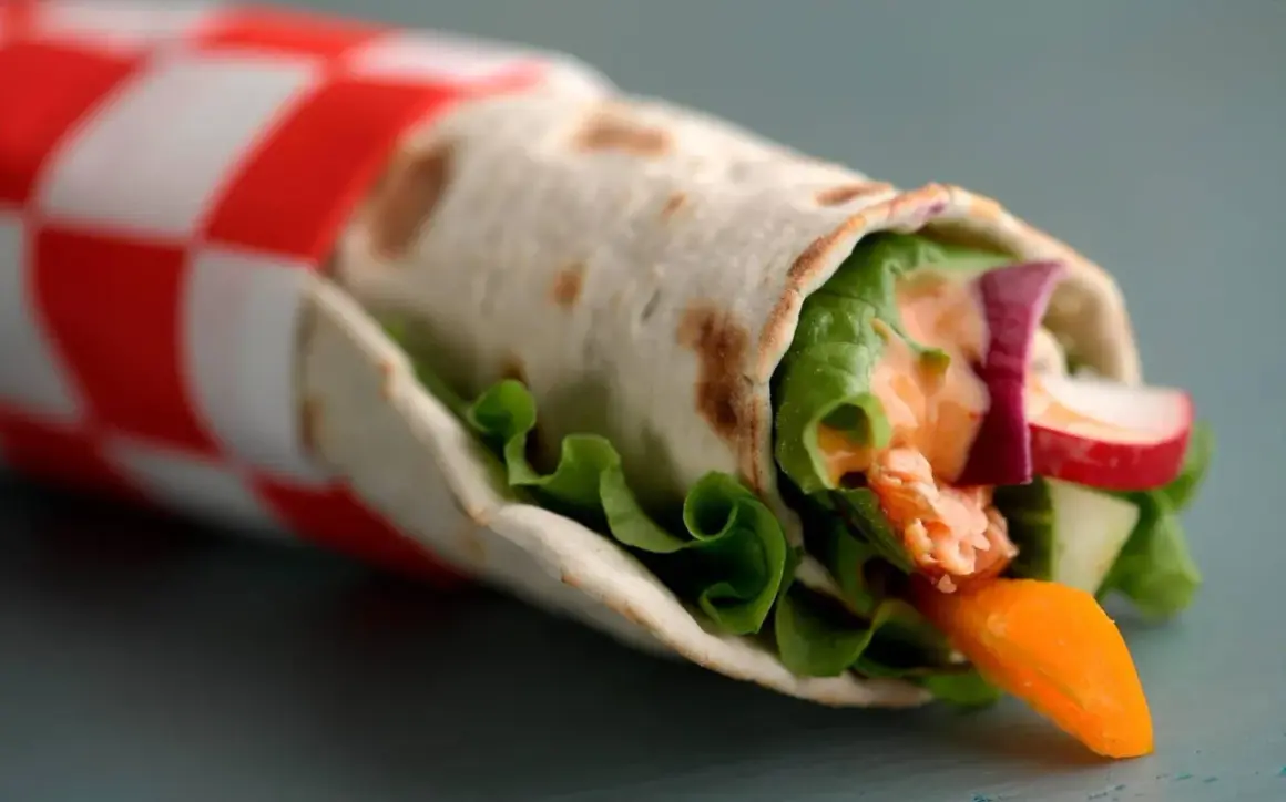 En läcker wrap med lax, sallad, gurka, rädisa och en krämig sås. Ett enkelt wraps recept för en snabb lunch.