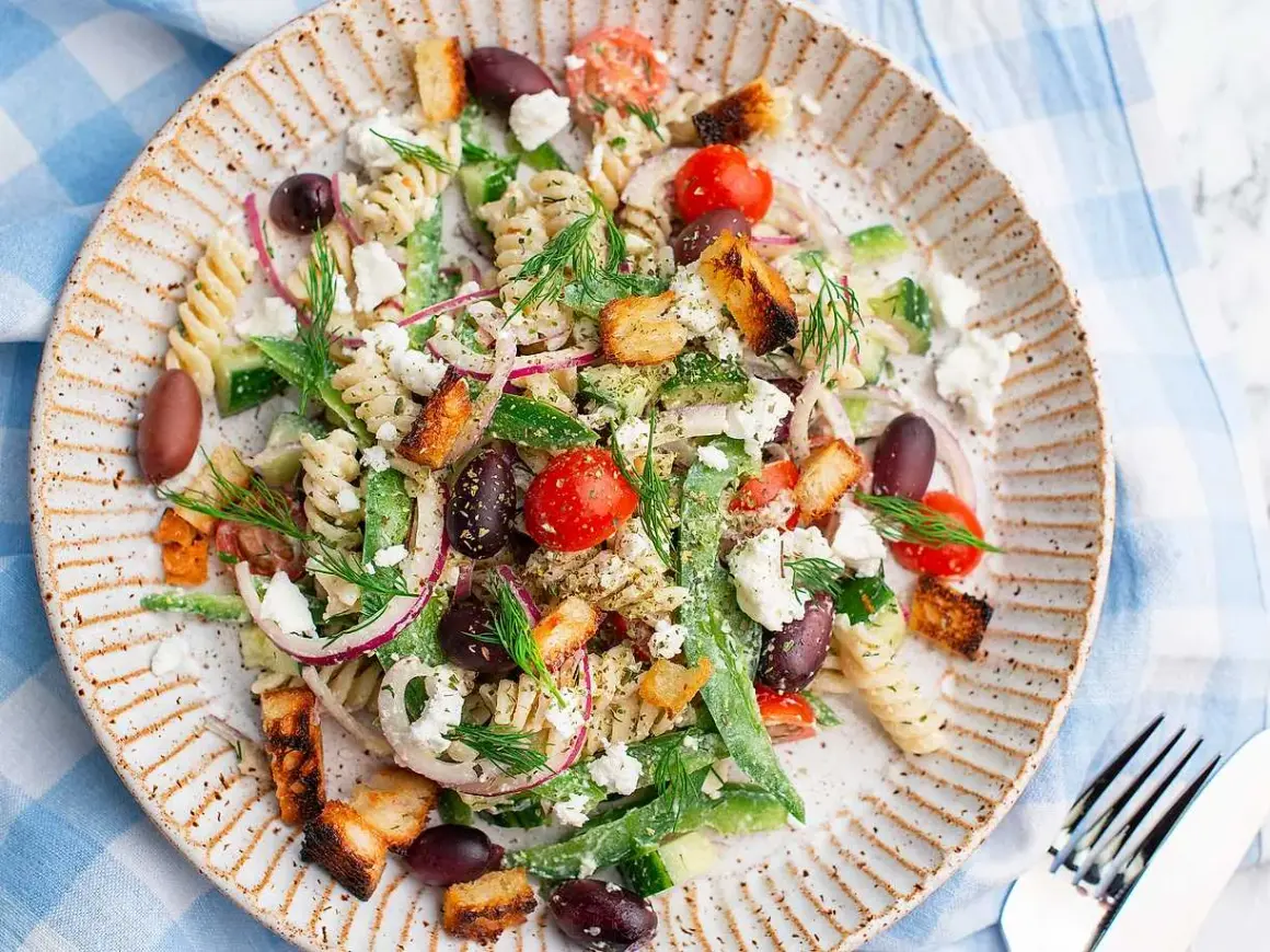 En härlig grekisk pastasallad med rotfrukter, fetaost, oliver och krutonger. Perfekt för en lätt lunch eller middag.