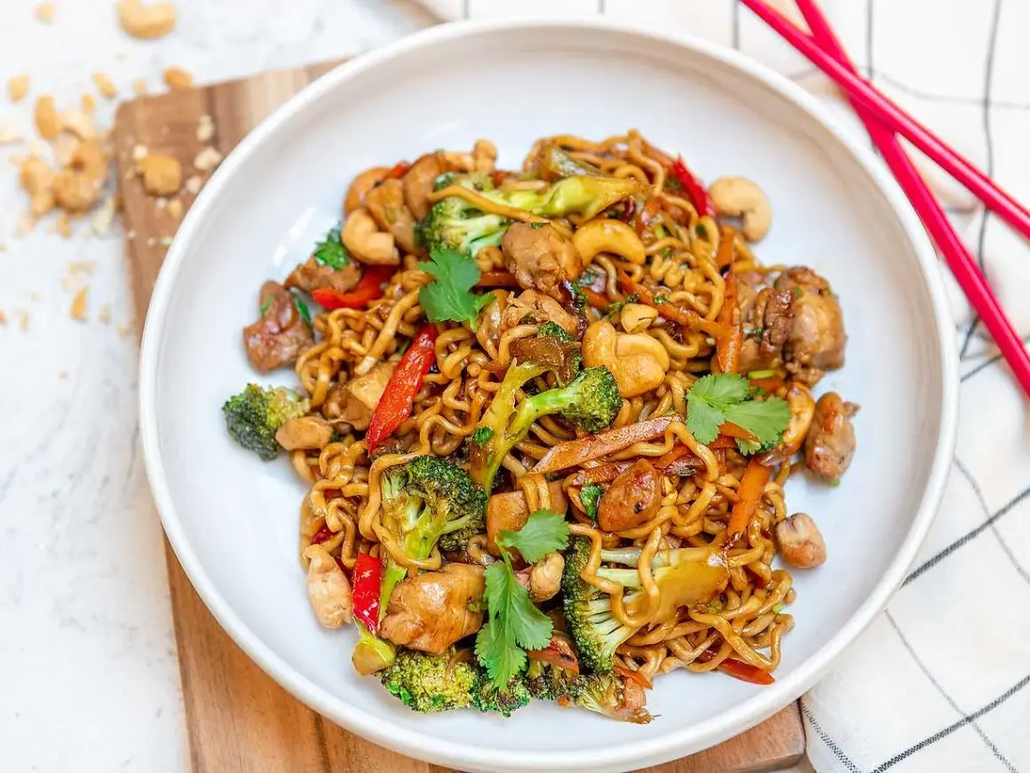 En skål med nudlar, kyckling, broccoli, paprika och cashewnötter. Perfekt för enkla middagar.