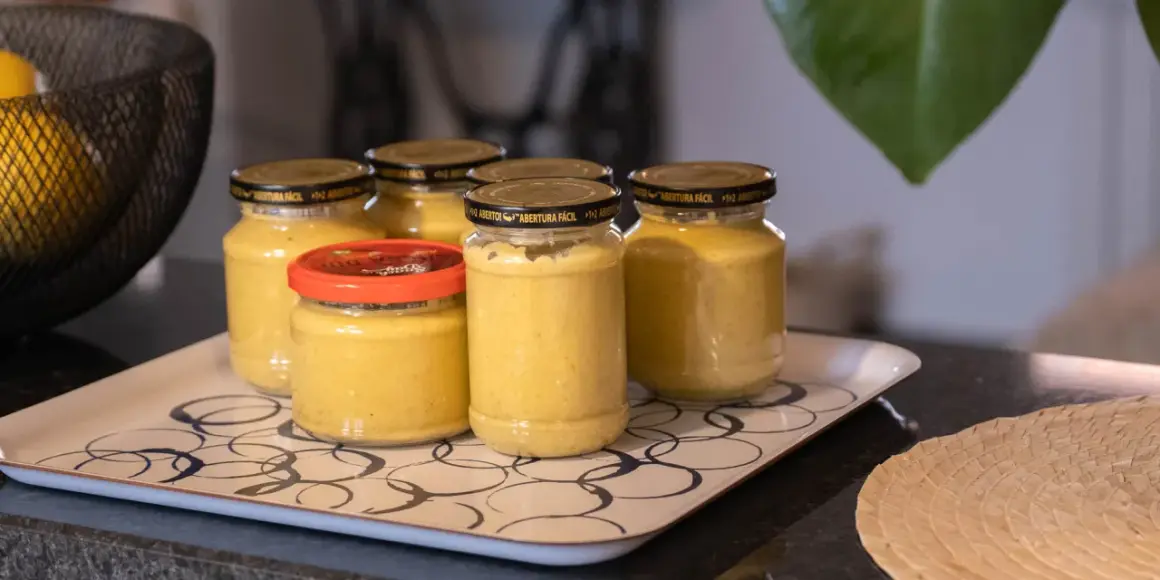 Burkar med hemlagad sambal oelek recept på en bricka. En skål med citroner syns i bakgrunden.