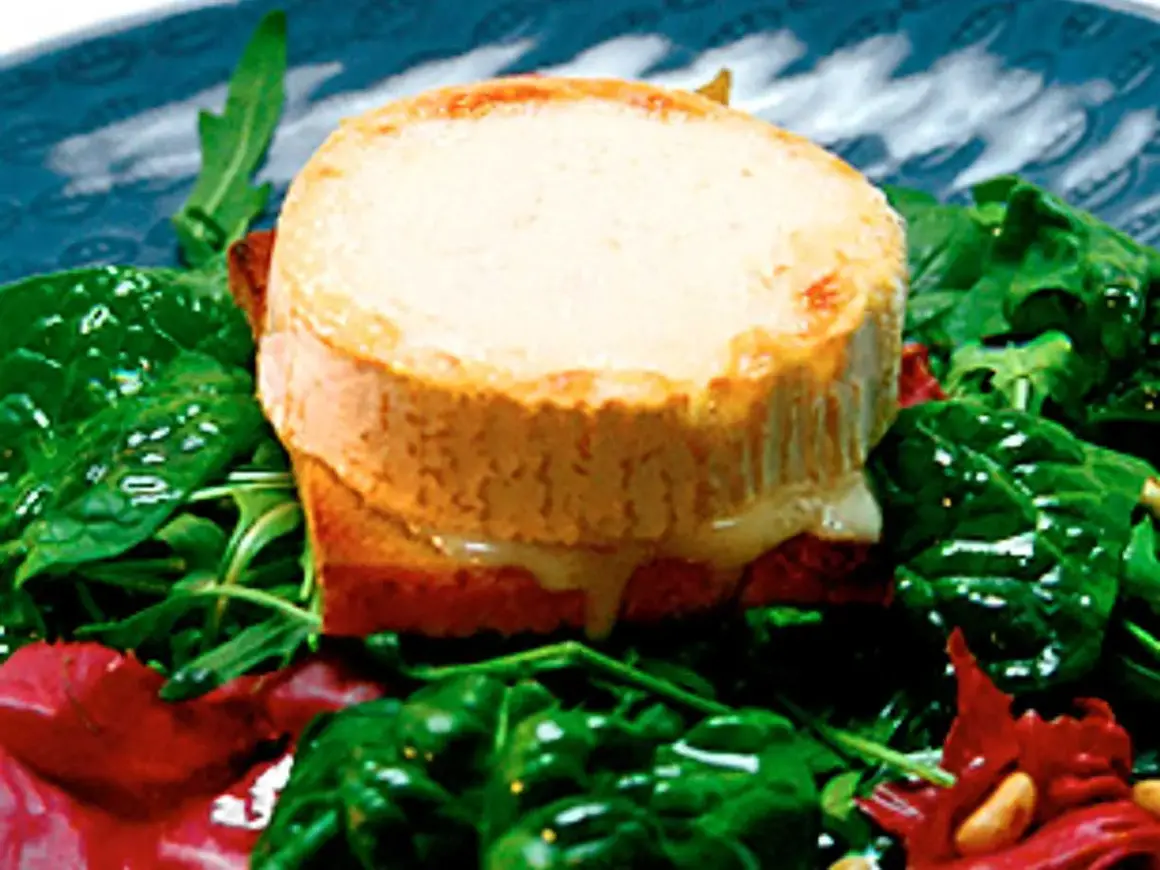 Varm chevre chaud på rostat bröd, serverad med en fräsch sallad av spenat och ruccola.