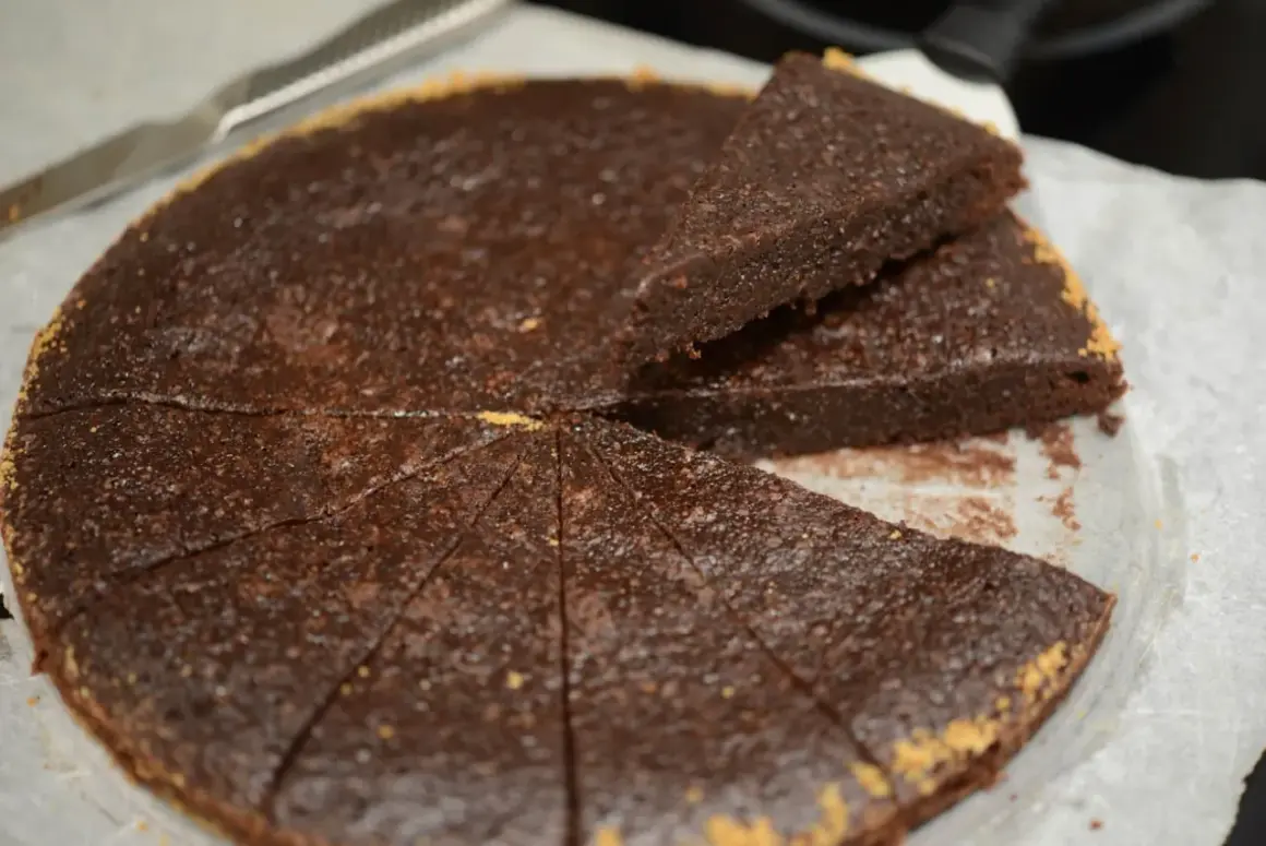 En saftig ica kladdkaka, uppskuren i bitar med en kniv bredvid.